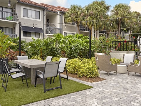 a patio with a table and chairs in a garden